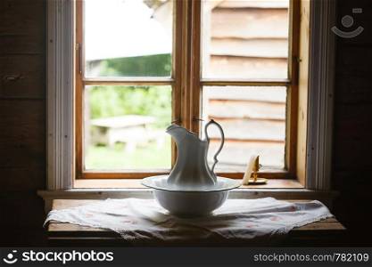 Old vintage objects, wood concept. Old vintage window and ceramic jug in foreground. Old vintage window, ceramic jug in foreground