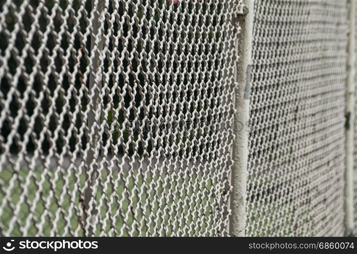 Old vintage painted metal fence mesh photographed at acute angle