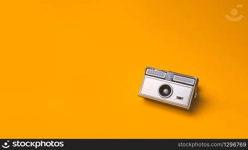 Old vintage Photo Camera on a yellow Background