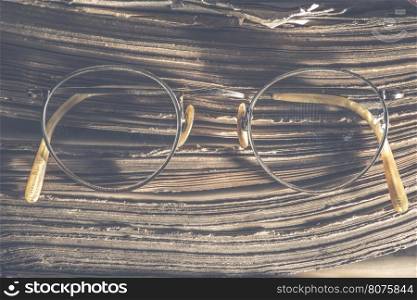 Old vintage round glasses and old book. Low light