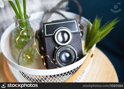 Old vintage rustic camera with a bouquet of daisy flowers on a wooden board. Close-up, bokeh.. Old vintage rustic camera with a bouquet of daisy flowers on a wooden board.