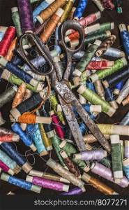 Old vintage scissors on spools of thread. Multicolored