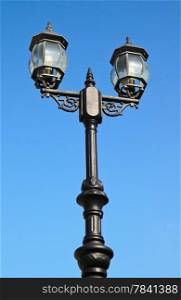 Old vintage street light against blue sky