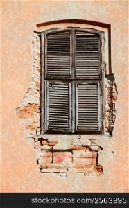 Old vintage unattained house window on ruined facade