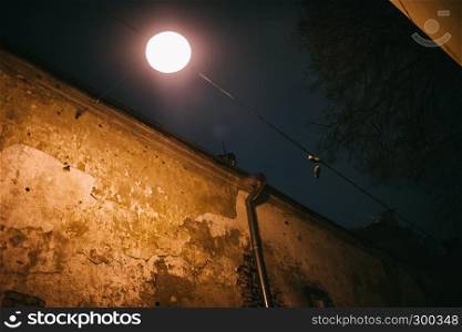 Old vintage Vilnius old town wall with bright street lantern at dusk