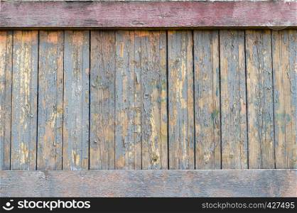 old wall of wooden boards with shabby yellow paint