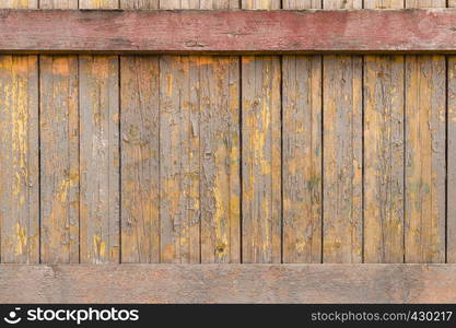 old wall of wooden boards with shabby yellow paint