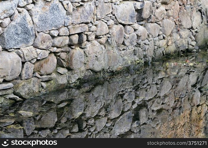 old water-mill wall and diagonal reflexion at water