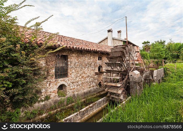 Old water mill with iron water wheel.