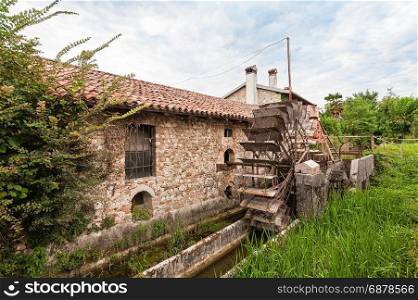 Old water mill with iron water wheel.