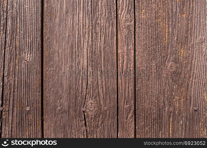 Old weathered brown painted wooden boards wall surface closeup as background