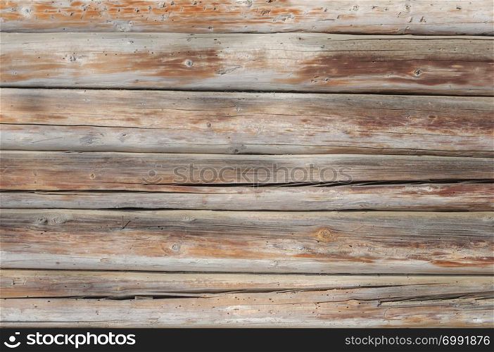 Old weathered cracked wooden wall of natural logs, background texture
