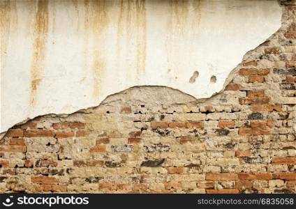 Old weathered grunge brick wall of rustic house with ruinous plaster