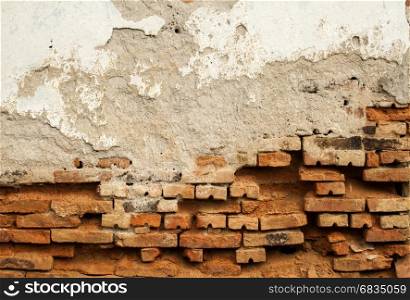 Old weathered grunge brick wall of rustic house with ruinous plaster