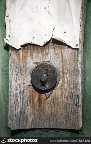 Old weathered grunge doorbell button on wooden plate