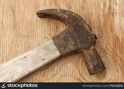 Old weathered grunge hammer adze head closeup on plywood surface