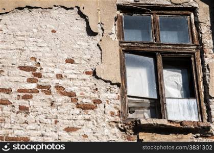 Old weathered grunge window of neglected abandoned townhouse facade
