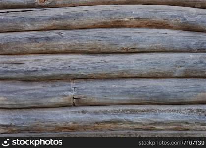 Old weathered natural unpainted wooden logs wall background