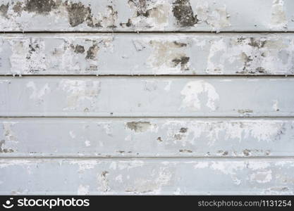 Old weathered paint peeling from the grey concrete wall. Abstract pattern textures wallpaper.
