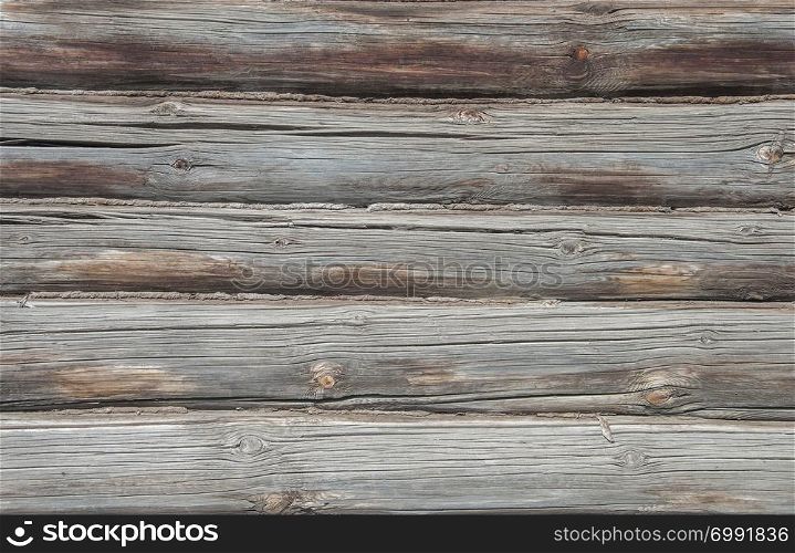 Old weathered wooden wall of logs, background texture