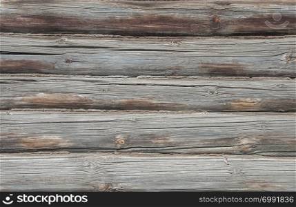 Old weathered wooden wall of logs, background texture