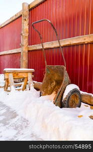 Old wheelbarrow with snow at village of Goloustnoye, Russia