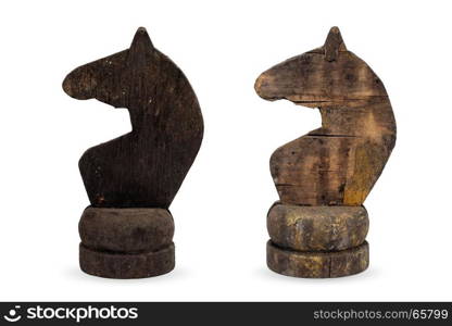 Old white and black chess knights. Isolated objects: two very old wooden chess pieces, knights, or horses, black and white