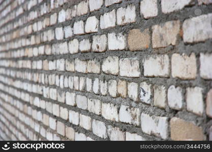 Old white brick wall in a projection leaving in a distance