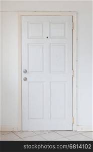 Old white door and a blank wall