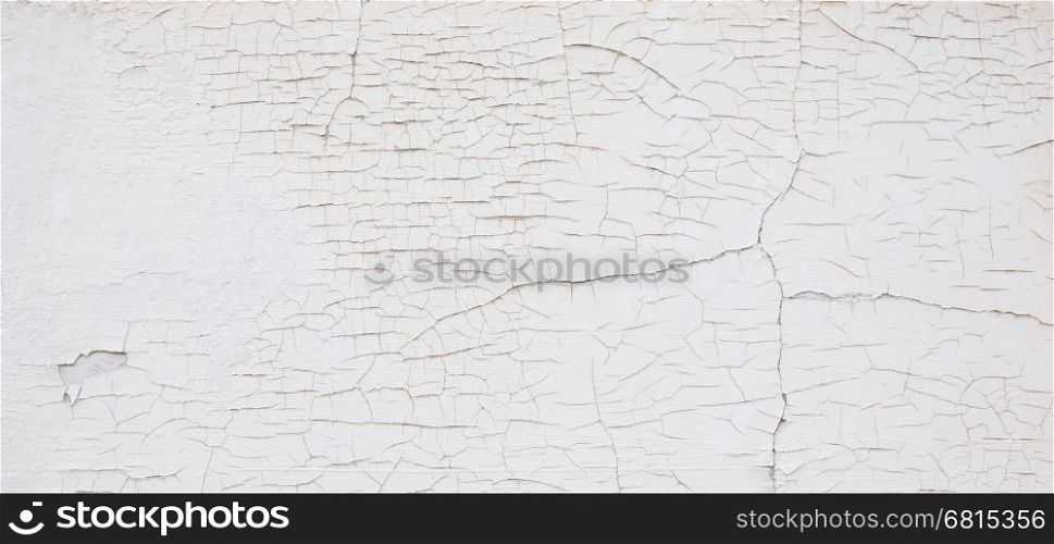 Old white wall with cracks, needs maintenance