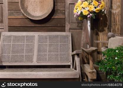 old wicker bench beside wood wall of antique retro vintage house at night