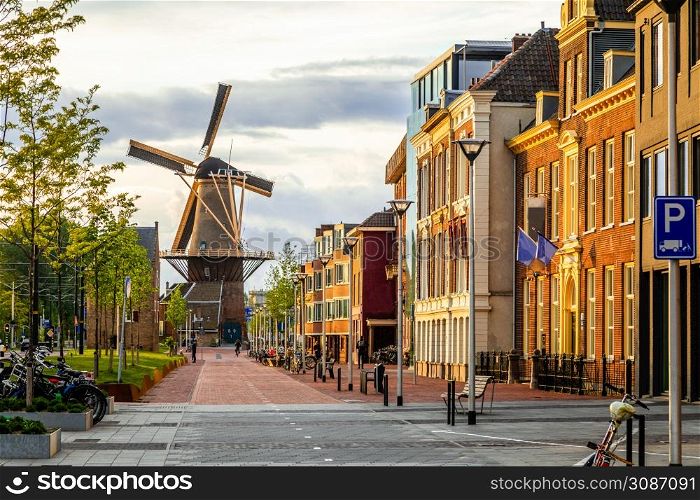 Old wind mill and street with modern buildings, Delft, The Netherlands
