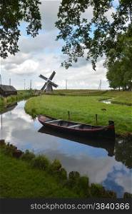old windmill and boat on small canal