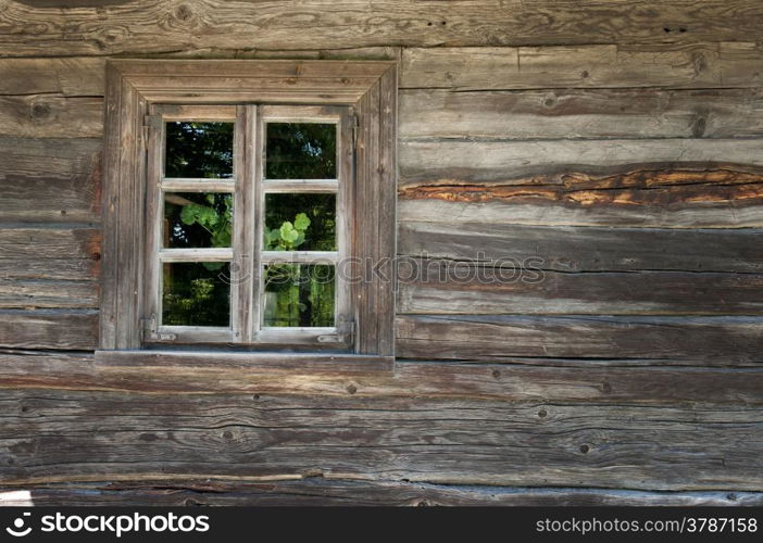 Old window on a wooden farm house wall