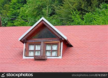 Old window on red shingled roof