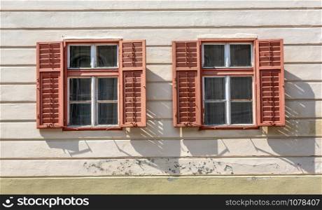 Old window with wooden shutters on stucco wall and copy space