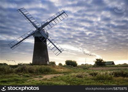 Old windpump windmill in English countryside landscape early morning