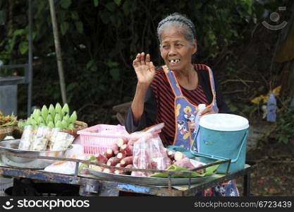 Old woman and fruit stall on the street in Ayutthaya, Thailand