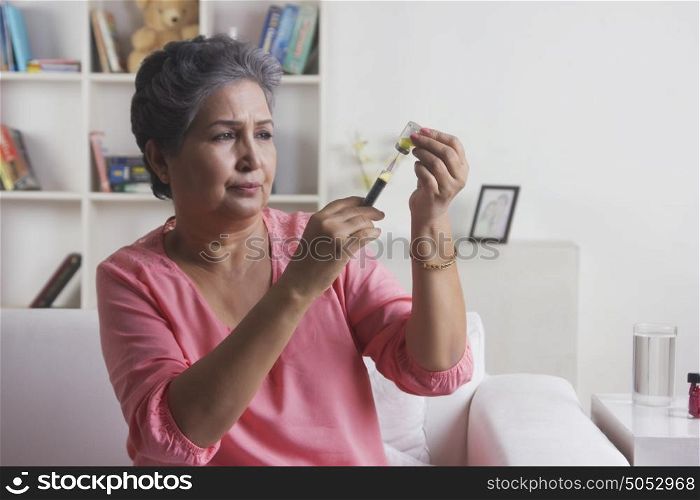 Old woman filling syringe with insulin