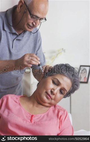Old woman getting ear drops put in