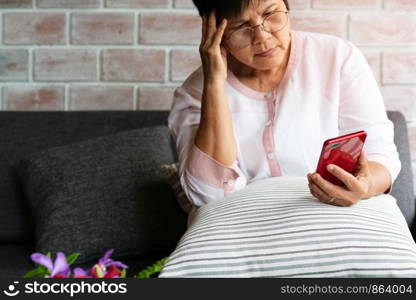 Old woman headache while using smartphone, healthcare concept