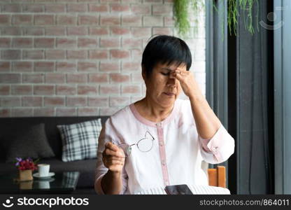 Old woman headache while using smartphone, healthcare concept