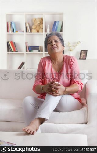 Old woman holding knee in pain