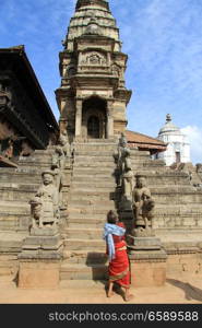 Old woman near steps on temple on the durbar in Bhaktapur, Nepal