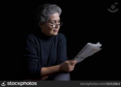 Old woman reading newspaper