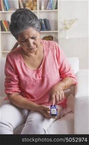 Old woman using glucose meter