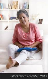 Old woman with hot water bag on leg