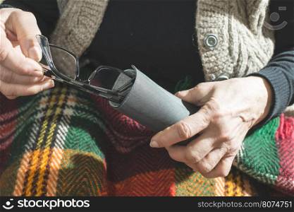 Old women hold glasses in pouch