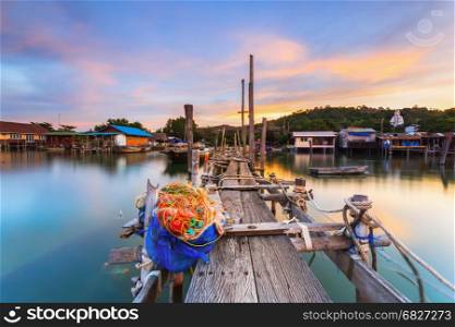 Old wood bridge for small fishing boat at fisherman village with sunset