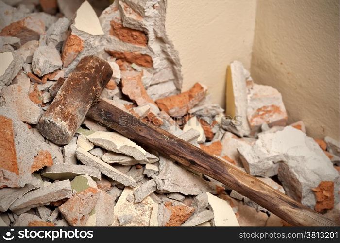 Old wood hammer on broken brick and cement in house demolition